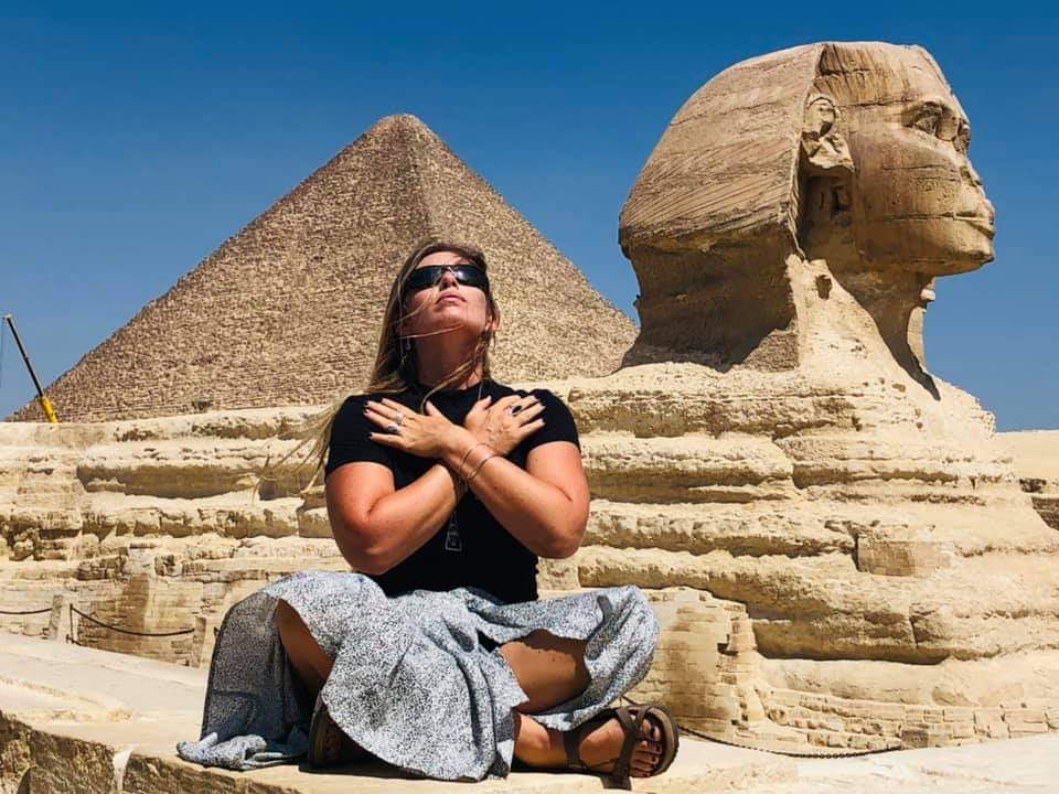 Woman sitting in meditation at the sphinx in Egypt